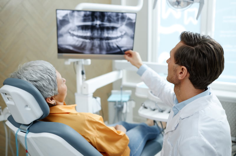 Dentist reviewing a patient's dental X-ray during a treatment consultation