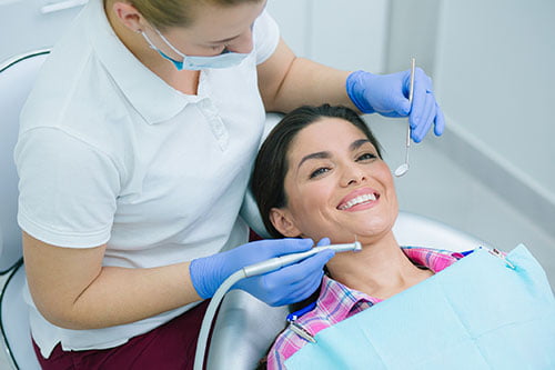 Patient smiling during a cosmetic dentistry consultation at a modern dental clinic.
