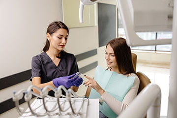 Dentist holding a clear aligner tray used for Invisalign orthodontic treatment.