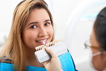 Patient consulting with a dentist about porcelain veneers to improve her smile.