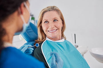 Patient smiling during a teeth whitening consultation at a dental clinic.