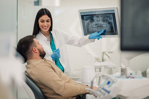 Dentist showing a dental X-ray to a patient after dental trauma or sports injury in Barrie