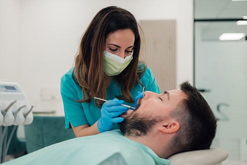 Dentist treating gum, lip, and cheek injuries during an emergency visit in Barrie