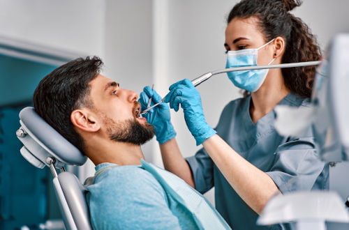 Dentist examining a patient's teeth during a routine dental checkup and cleaning appointment