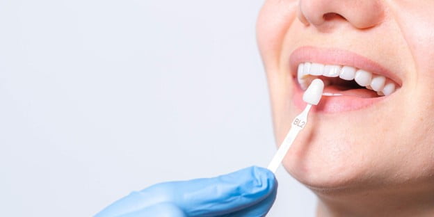 Dentist checking a patient's porcelain veneer during a dental appointment
