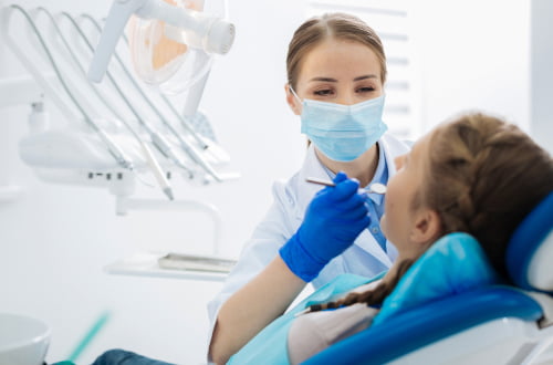 A dentist providing restorative dental treatment to a patient during a clinic appointment