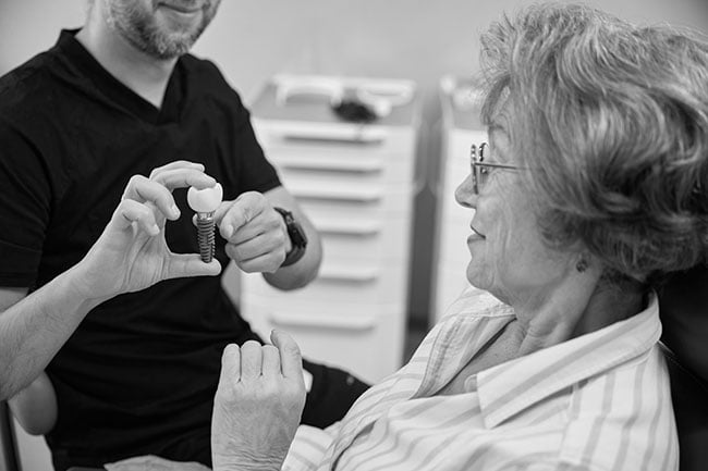 A dentist explaining an All-on-4 dental implant solution to a patient during a consultation in Barrie
