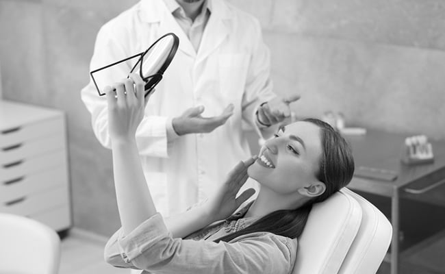 Young woman reviewing her restored smile during a crown and bridge dental consultation in Barrie