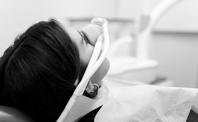 Adult patient wearing a sedation mask during a comfortable dental treatment appointment in Barrie
