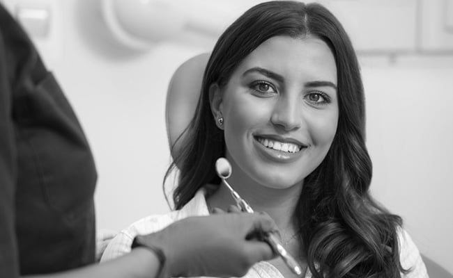 Young woman smiling confidently after a Teeth in a Day / All-on-4 dental restoration consultation in Barrie