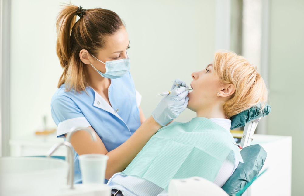 Dentist performing a dental deep cleaning with scaling and root planing