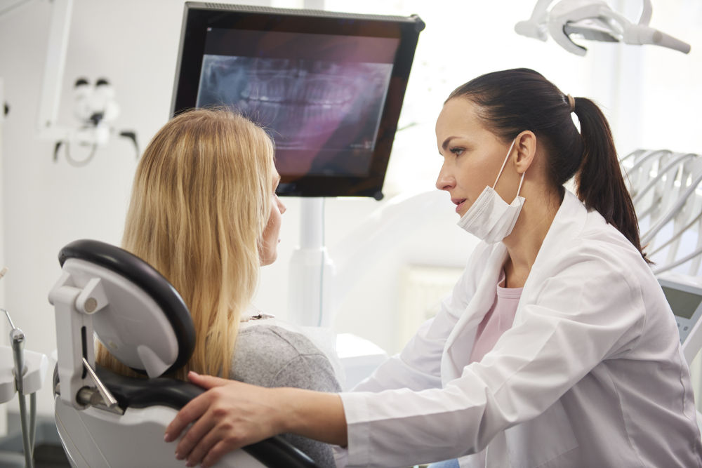 dentist explaining root canal symptoms to a patient during a dental consultation