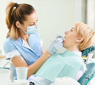 Dentist performing a dental deep cleaning with scaling and root planing