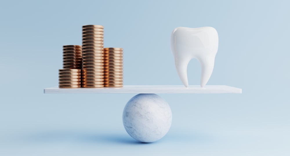 Tooth balancing on a scale with a golden coin, representing the cost-benefit of dental insurance in Canada